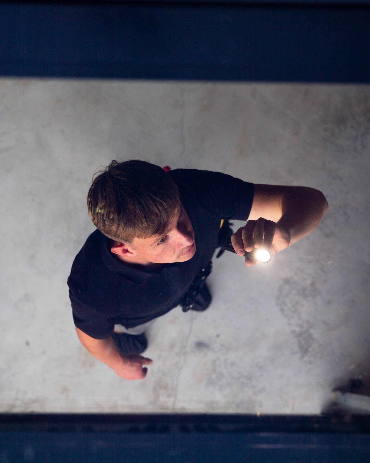 Sam Belza using a flashlight while inspecting a residential space