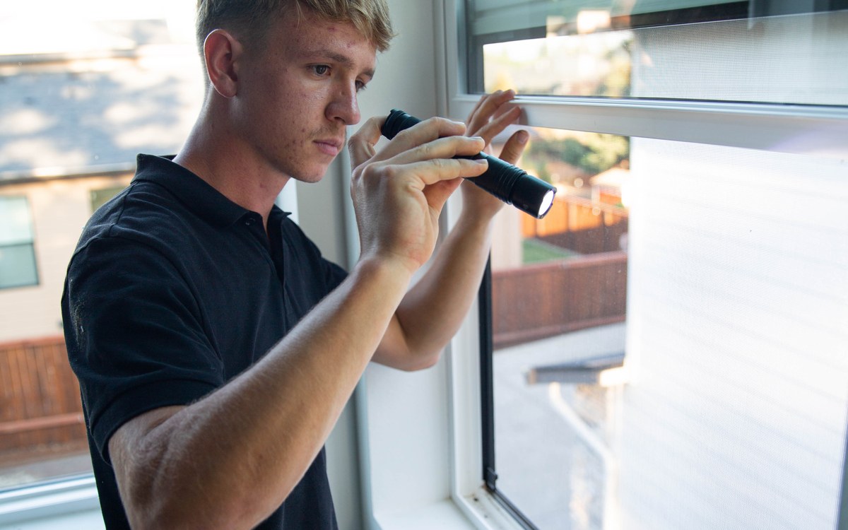 Sam Belza inspecting a window during a pre-purchase home inspection