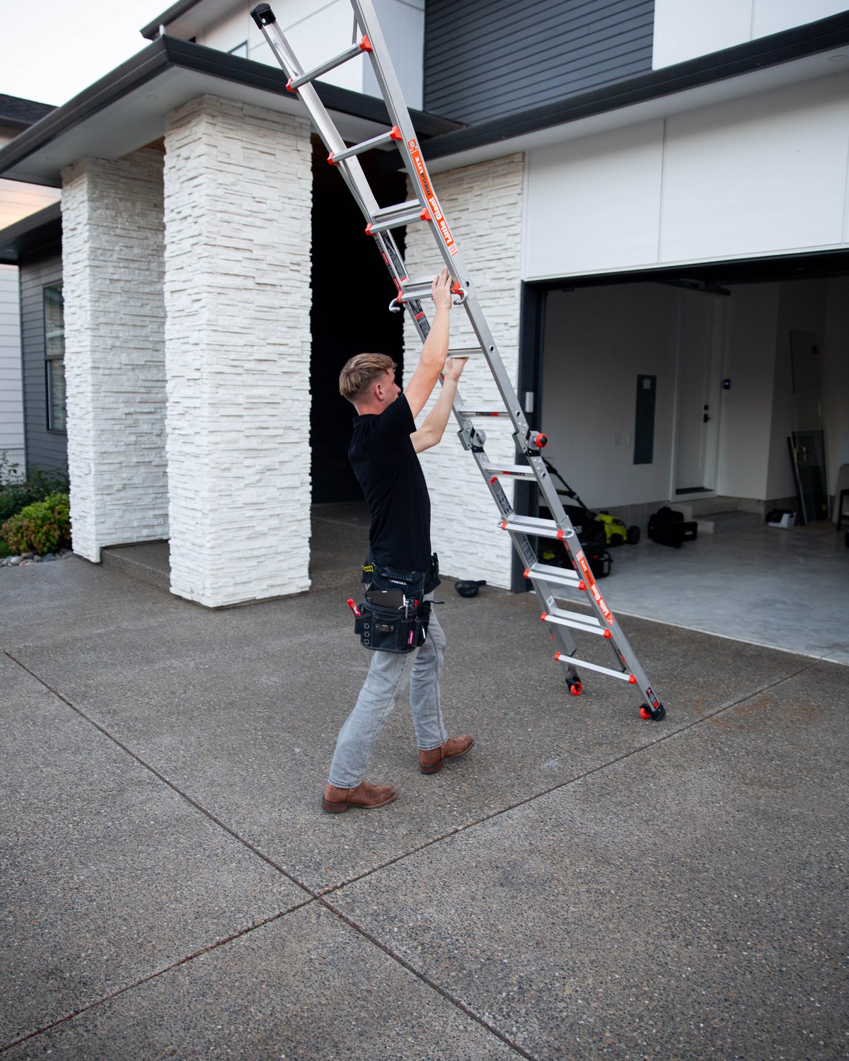 Sam Belza positioning a ladder to inspect a residential roof