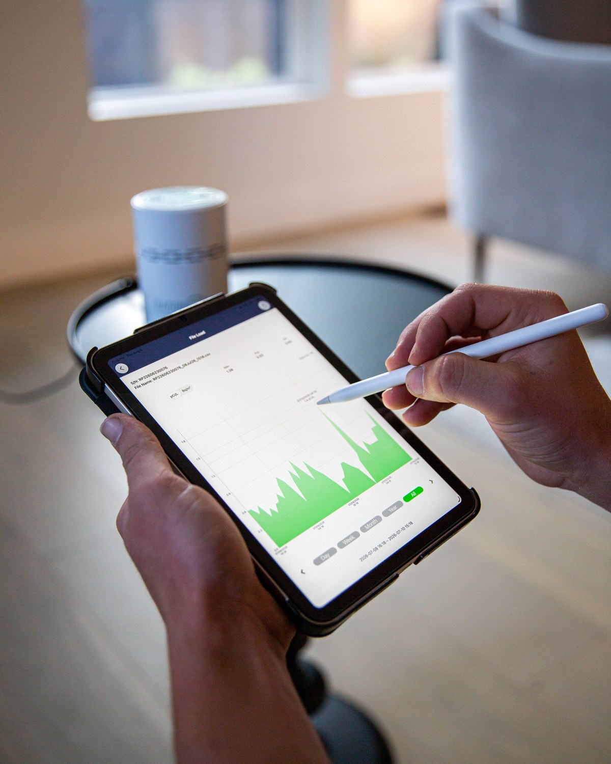 Tablet displaying measured radon results beside a residential testing monitor