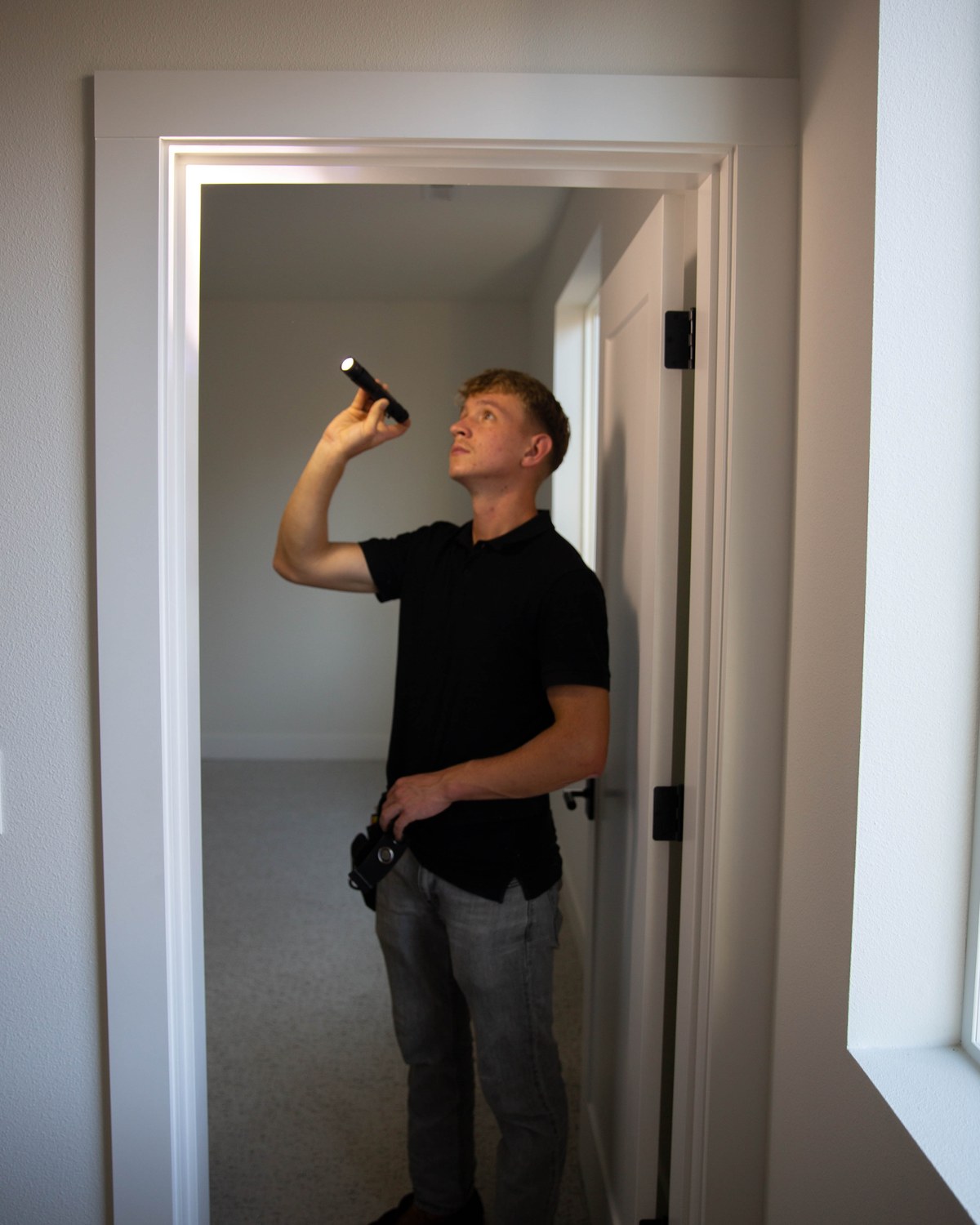 Sam Belza checking interior walls and ceilings during a home inspection